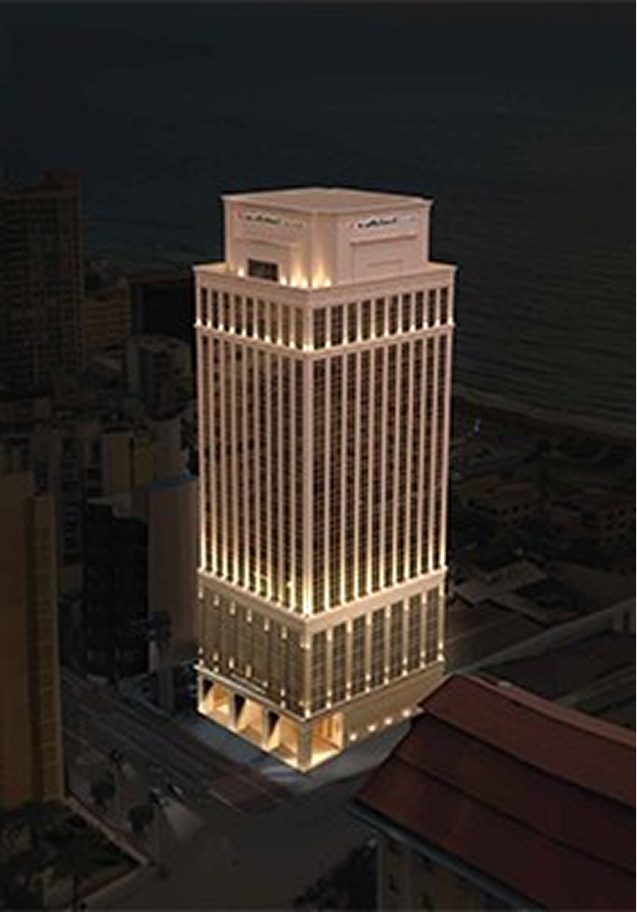 An illuminated tall corporate building at night.